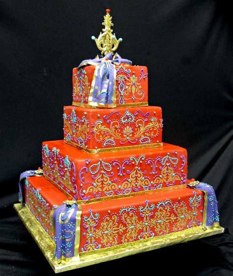 colorful indian wedding cake cake is covered in red fondant gold design is stenciled on the