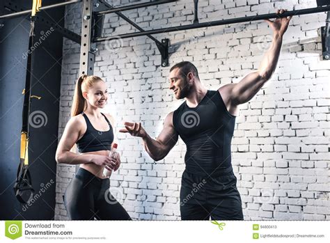 sportsman gesturing and talking to attractive sportswoman in sports center stock image image