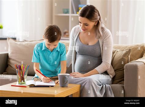 Pregnant Mother And Son With Workbook At Home Stock Photo Alamy