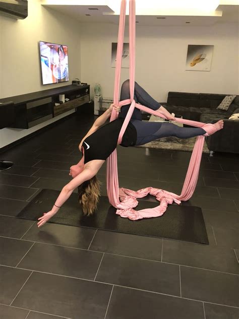 Two Women Doing Aerial Acrobatic Exercises In A Living Room With Black