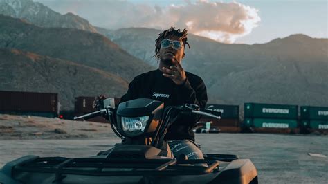 American Rapper Juice Wrld On Motor Bike In Mountains Background