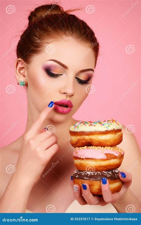 Girl With Dark Hair And Bright Makeup Holding Sweet Donuts Stock Image