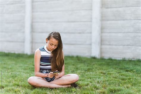 Teen Girl On Cell Phone Outdoors Del Colaborador De Stocksy Ronnie Comeau Stocksy