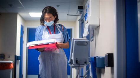 A doctor checks on patients notes at the NHS Seacole Centre in Surrey
