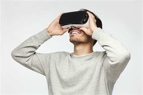 handsome man playing video games in vr goggles or 3d glasses wearing virtual reality headset for