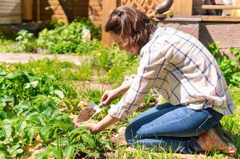 Premium Photo A Woman Is Gardening In Her Backyard She Plants Seedlings
