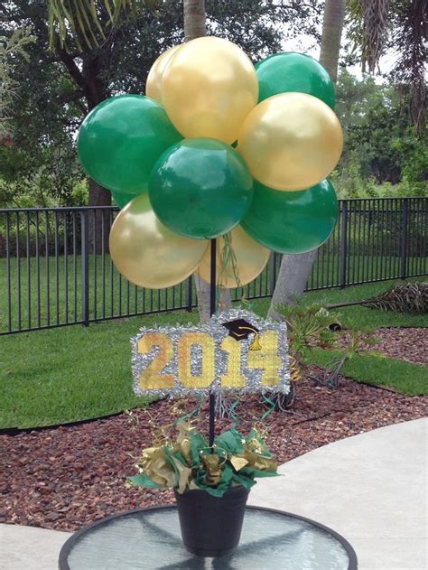 Decorate your graduation party table with confetti featuring photos of your graduate. Green and gold balloon centerpieces for a Baylor ...