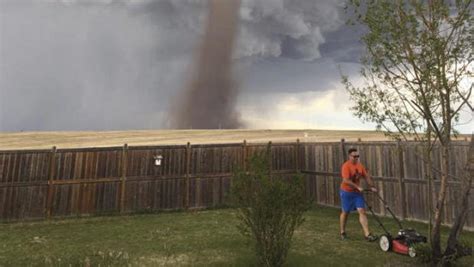 Photo Of Man Mowing Lawn With Tornado Behind Him Creates Social Media