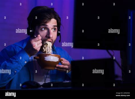 Male Gamer Eating Noodle Soup Playing Video Games Stock Photo Alamy