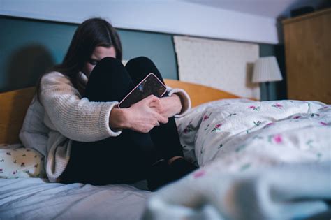 Sad Teen With A Phone In Her Bedroom Stock Photo Download Image Now