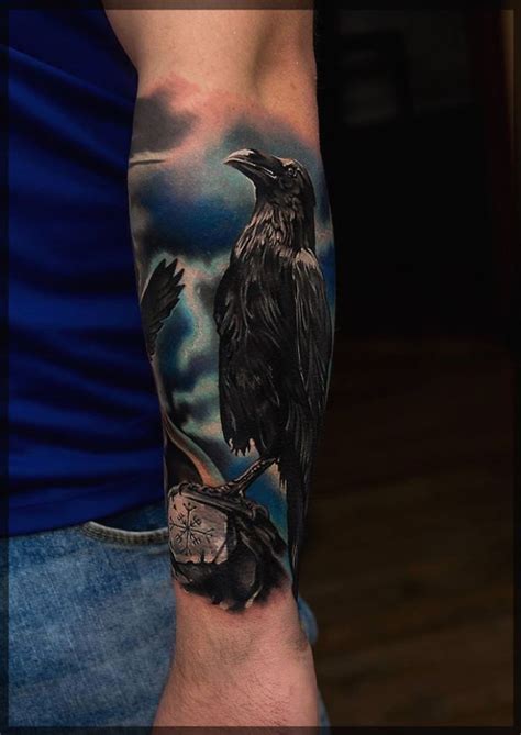 A Man With A Tattoo On His Arm Has A Black Crow And Flowers In It