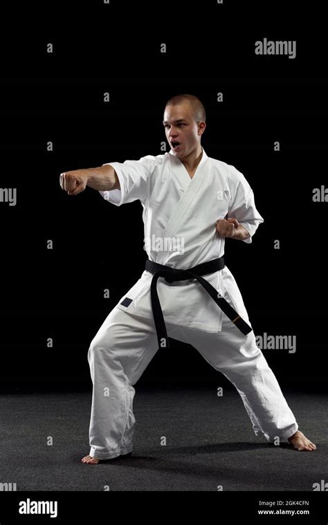 Full Length Portrait Of Young Sportsman Training Karate Isolated Over