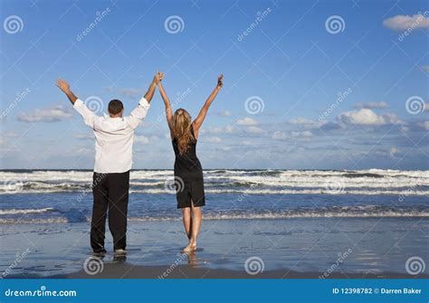 Couple Celebrating Arms Raised On A Beach Stock Photo Image Of Woman