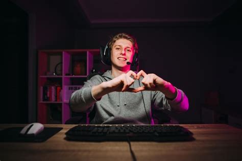 Premium Photo Happy Guy Gamer In A Headset Shows A Heart Gesture And