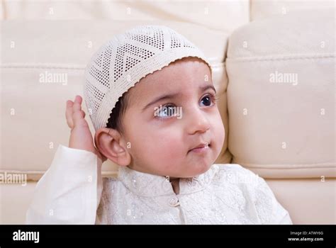 Cute Muslim Baby In Traditional Islamic Clothing Looking Up Hand On