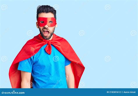 Young Handsome Man With Beard Wearing Super Hero Costume Winking