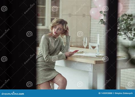 Slim Wife Wearing Short Dress Sitting And Waiting For Husband Stock