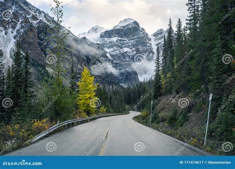 Driving On Highway With Rocky Mountains In Autumn Forest At Moraine