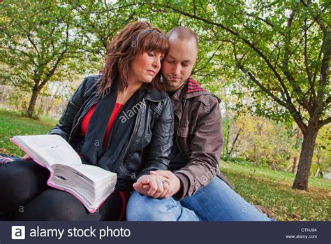 Couple Reading Bible And Praying Together In The Park Edmonton