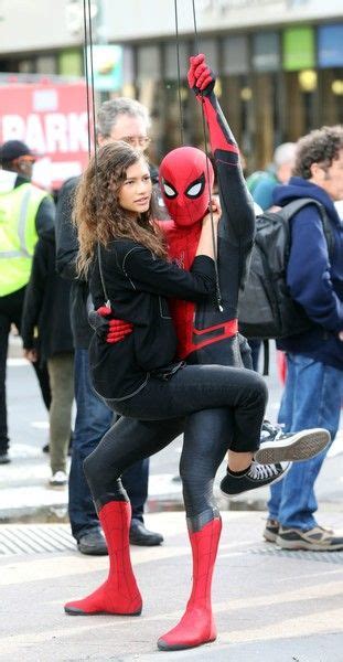 A Woman Dressed As Spider Man Is Holding Onto The Strings