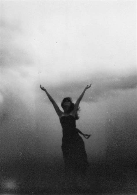 a woman standing in the water with her arms up