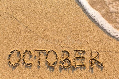 October Word Drawn On The Sand Beach With The Soft Wave Stock Image