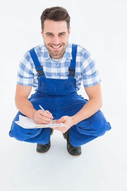 Premium Photo Happy Repairman Crouching While Writing On Clipboard