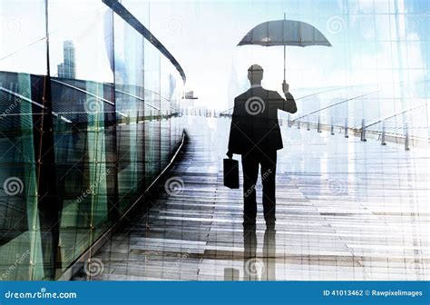 Depressed Businessman Standing While Holding An Umbrella Stock Photo