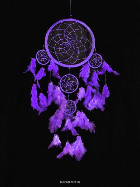 A Purple Dream Catcher With Feathers Hanging From Its Side On A Black