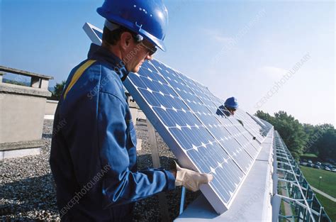 How to install solar panels to your roof. Installing solar panels on a roof - Stock Image - T152/0555 - Science Photo Library