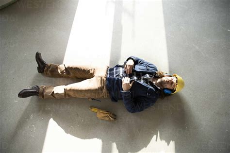 Construction Worker Sleeping On Floor In Renovating House Stock Photo