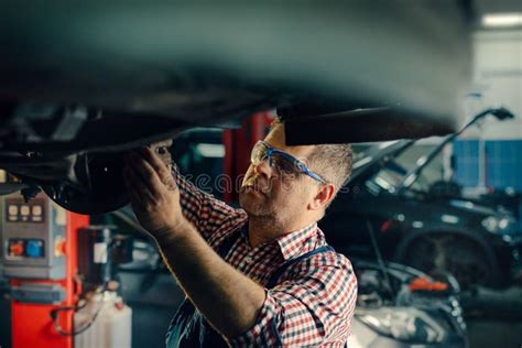 Portrait Shot Of A Handsome Mechanic Working On A Vehicle In A Car