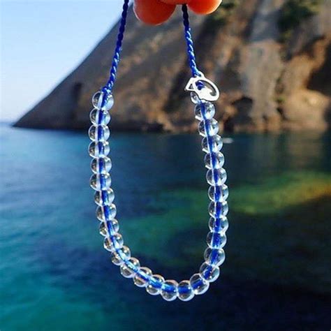 An Orange And Blue Beaded Necklace Hanging From The Side Of A Cliff By