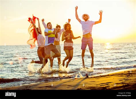Group Of Happy Young People Dancing At The Beach On Beautiful Summer