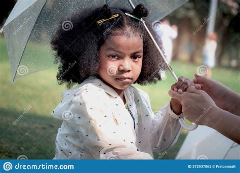 Portrait Of African Girl With Black Curly Hair With Parent Hands Hold