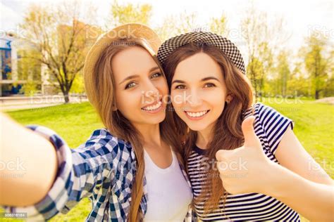 Pretty Girls With Beaming Smiles Shooting And Showing Thumb Up Stock