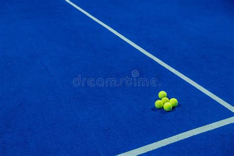 Five Paddle Tennis Balls On The Artificial Grass Surface Of A Blue