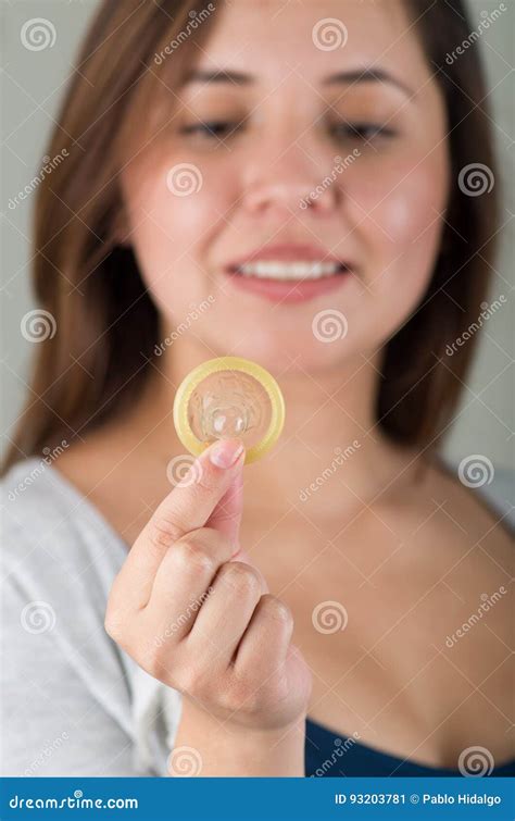 Close Up Of A Beautiful Young Woman Holding An Open Condom For Aids