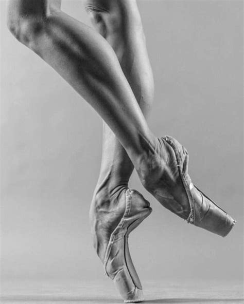 black and white photograph of a woman s legs in ballet shoes