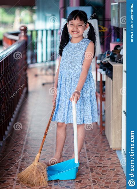 Smile Asian Little Girl Sweeping With Broom And Dustpan In The House