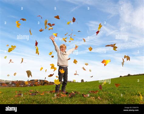 Boy Playing In Fall Leaves Stock Photo Alamy