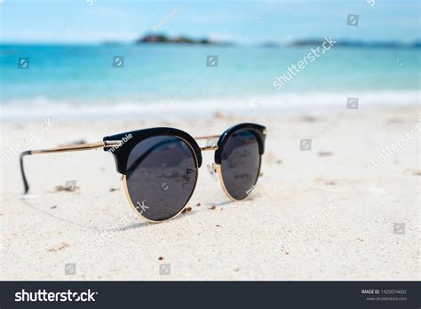 Black Sunglasses On The Sea Background Beautiful Sand Beach As