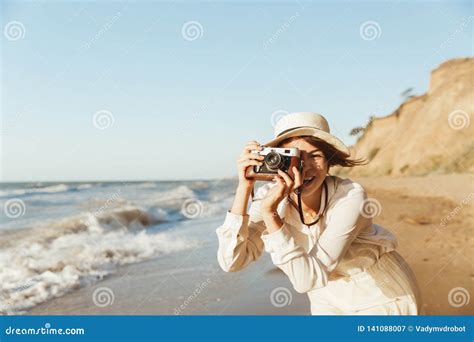 Image Of Cheerful Woman S Photographing On Retro Camera While Walking By Seaside Stock Image