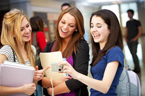High School Girls Laugh At Funny Picture By Stocksy Contributor