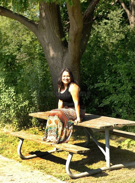 Lovely Woman Sitting On A Picnic Table In The Park Stock Photo Image