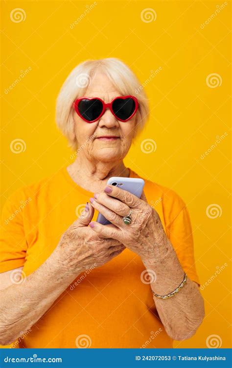Portrait Of An Old Friendly Woman In Dark Glasses Talking On The Phone Background Stock Image