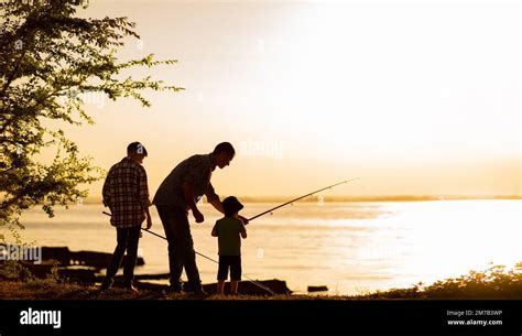 Padre De La Familia Y Dos Hijos Están Pescando Al Atardecer Silueta De