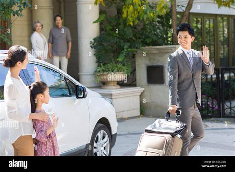 Mother and daughter waving goodbye to father Stock Photo - Alamy