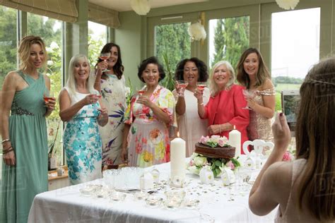 Girl Photographing Female Wedding Guests At Reception Stock Photo