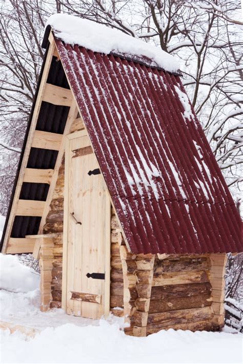 Wooden House From Log With Red Roof In Winter Forest Stock Image